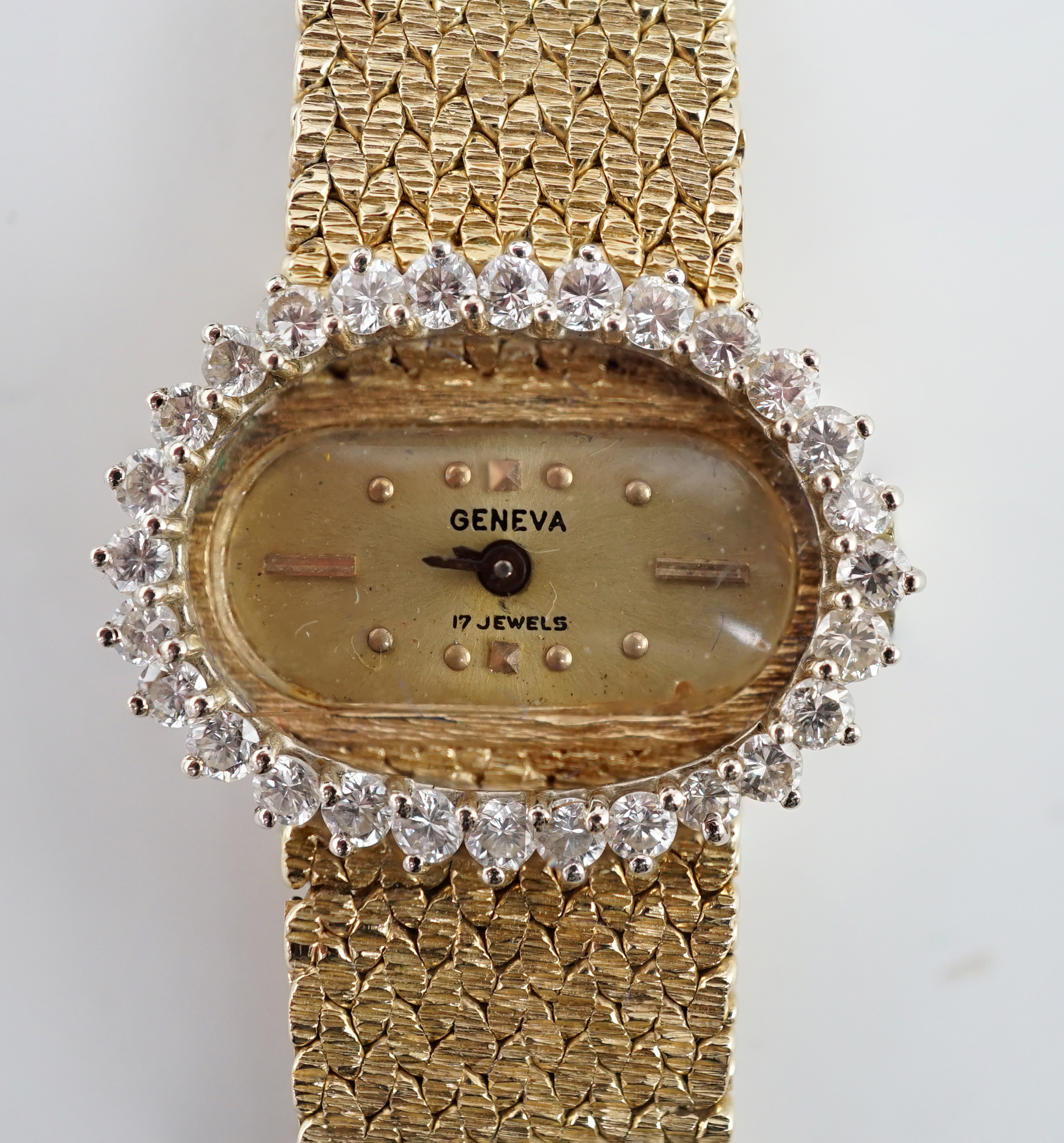 A lady's modern Swiss 14k gold and diamond set manual wind oval wrist watch, on integral 14k gold bracelet